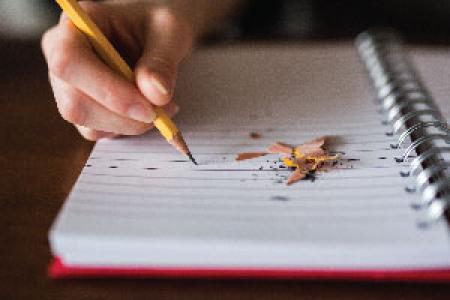Photo of person writing in notebook