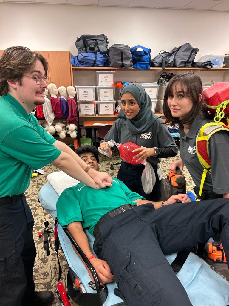 A group of MRU members renacting CPR on themselves in a playful manner
